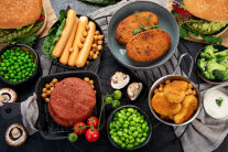 Teller und Schüsseln mit Gemüse und Fleischersatzprodukten