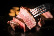 Ein Stück rotes Fleisch auf einer Gabel