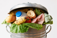 Mülleimer, der mit einwandfreien Lebensmitteln gefüllt ist