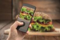 Smartphone, mit dem ein Bild von einem Burger aufgenommen wird